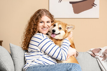 Young woman hugging with Corgi dog at home