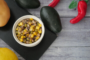 Vibrant bowl of corn and beans on wood table