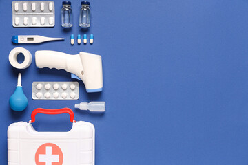 First aid kit and different medical supplies on blue background