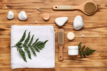 Fototapeta na wymiar Composition with spa stones, jar of cosmetic product and bath accessories on wooden background