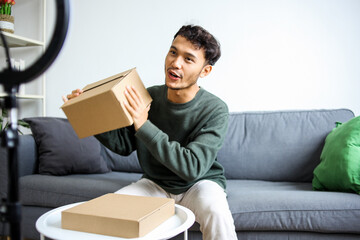 Male Influencer Presenting Cardboard Box To The Camera For Unboxing Video Or Product Review