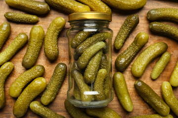 Jar with tasty pickled cucumbers on wooden background