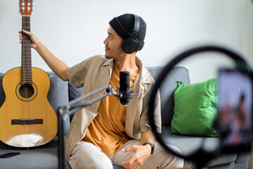 Young Asian Musician Posing With Acoustic Guitar For Online Recording Or Live Stream