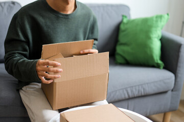 Content Creator Sitting On Sofa Enthusiastically Talking About Product From Cardboard Box