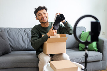 Content Creator Sitting On Sofa, Showing Product In Cardboard Box To Audience