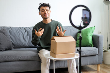 Young Asian Man As Content Creator Talking To Smartphone With Gesturing Hands During Live Streaming