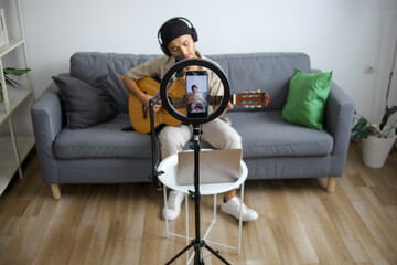 Male Musician With Headphones Singing And Playing Acoustic Guitar Recording By Smartphone
