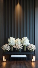 Floral display with candles against a dark, vertical-striped wall & wood floor