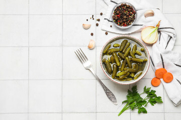Bowl with tasty pickled cucumbers and different ingredients on white background
