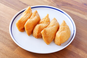 いなり寿司 - 甘辛く煮た油揚げに酢飯を詰めた稲荷寿司
