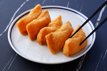 いなり寿司 - 甘辛く煮た油揚げに酢飯を詰めた稲荷寿司
