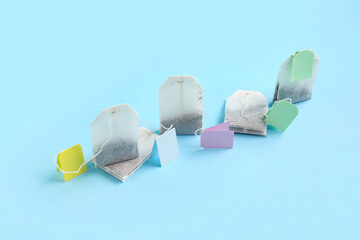 Different tea bags on blue background, closeup
