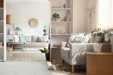 Interior of living room with comfortable sofas, tables and shelving unit