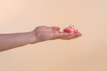 Fruit jelly mixed with sugar and hand on cream background