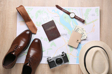 Male traveler's accessories on wooden floor, top view