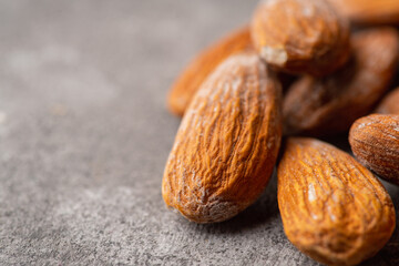 Pealed almond nuts on the gray concrete background. Healthy food. Selective focus.