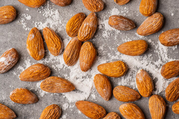 Pealed almond nuts on the gray concrete background. Healthy food. Shot from above.