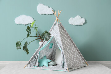 Interior of modern children's room with teepee and houseplant near mint wall © Pixel-Shot