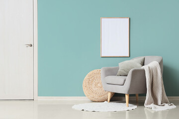 Interior of living room with comfortable armchair and pouf near mint wall