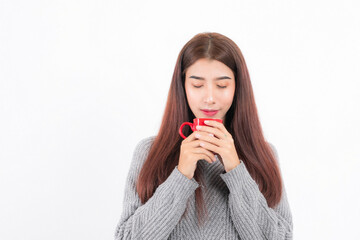 ฺBeautiful Asian woman in gray cozy sweater to enjoy moment hot beverage in a vibrant red cup studio shot on white background.