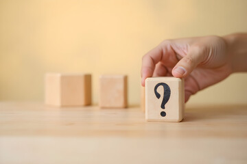 Hand Holding Wooden Block with Question Mark Symbol