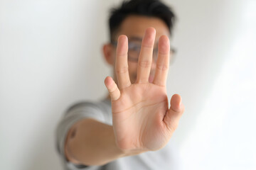 Person Showing Stop Hand Gesture Against Plain White Background