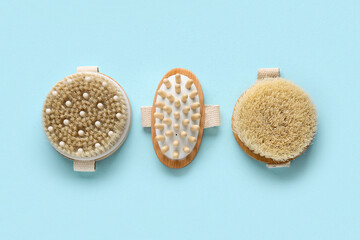 Different massage body brushes on blue background, closeup