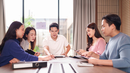 Asian business professionals discuss projects collaborate strategy analyze data working together sharing ideas planning future initiatives modern office meeting room environment