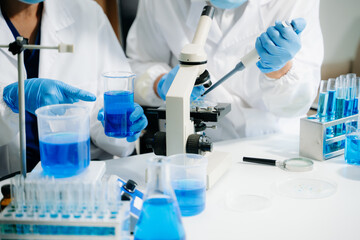 Fototapeta premium Scientists in a clean lab environment analyzing samples using test tubes and a tablet, showcasing modern biotech research, diagnostics, and medical innovation.