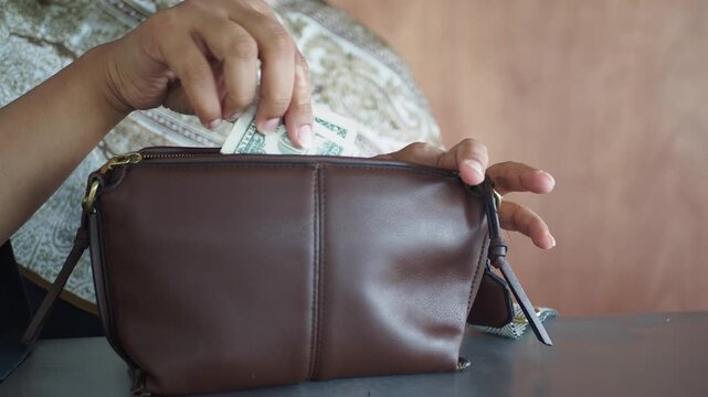 hands putting money into a purse