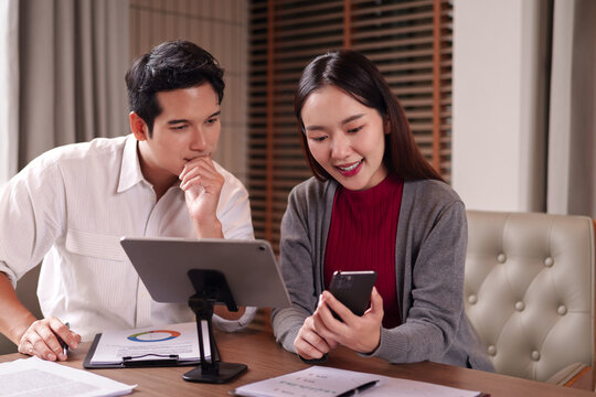 Asian adult business professionals collaborate review data using tablet smartphone documents modern office meeting room strategy project analysis development growth