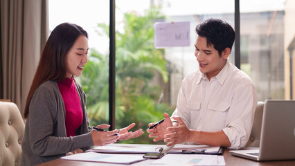 Obraz premium Asian Business Professionals Discussing Important Strategy Ideas Collaborating Intently Sharing Insights Modern Office Meeting Room Environment