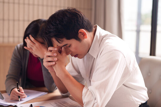 Asian adult professionals facing business financial problems during office meeting corporate struggle economic hardship challenging times