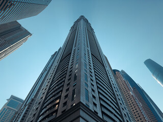 Obraz premium Modern steel and glass skyscrapers with blue sky reflections define the corporate architecture of downtown Chicago
