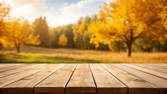 Empty weathered wooden table surface in the foreground with a blurred background of a vibrant autumn forest landscape during golden hour