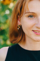 Half Face Portrait of Smiling Redhead Woman Outdoors