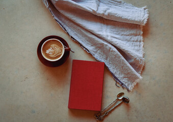 Red hard covered book and coffee cup with teaspoons vintage