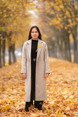 Portrait of a young beautiful long-haired girl in autumn outdoors.