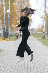 Portrait of a young beautiful long-haired girl in autumn outdoors.