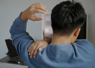 Young man suffers from neck pain along with shoulder pain, office syndrome, muscle problems,...
