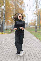 Fototapeta premium Portrait of a young beautiful long-haired girl in autumn outdoors.