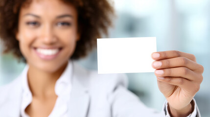 Clear white business card for copy space, holding by blurred smiling businesswoman in suit.