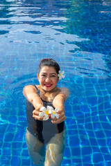 Summer day lifestyle woman relax and chill near luxury swimming pool sunbath at the beach resort outdoors the hotel. Summer Concept