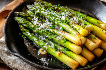 grilled asparagus spears with parmesan cheese and fresh herbs in cast iron skillet showing perfect char marks and caramelization for gourmet vegetable side dish