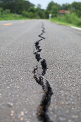 The road surface is cracked, the asphalt is damaged, cracked.