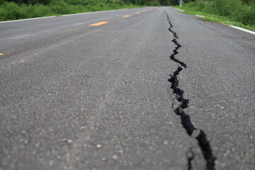The road surface is cracked, the asphalt is damaged, cracked.