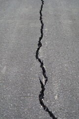 The road surface is cracked, the asphalt is damaged, cracked.