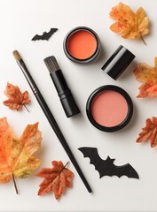 A flat lay of Halloween makeup products, including black eyeliner and orange blush on a white background.