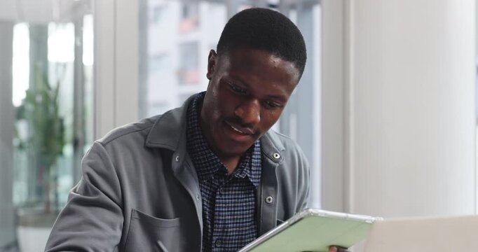 Business, black man and reading on tablet in office for research, editor feedback and article ideas. Journalist, digital and writing notes for story, fact check and draft update of publication agency