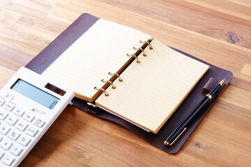 Calculator with opened notebook on table
